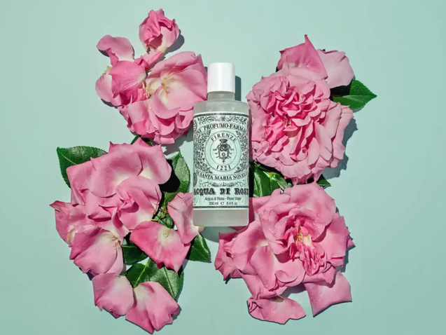 Profumo acqua di rose con fiori intorno